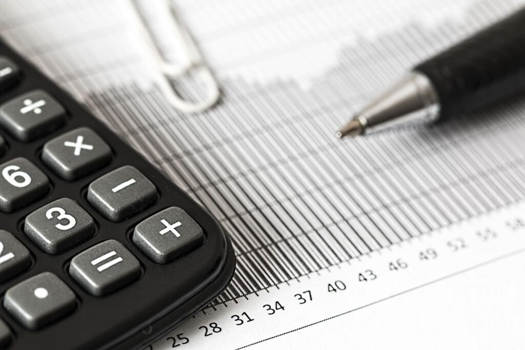 a pen on a printed graph next to an accountants calculator
